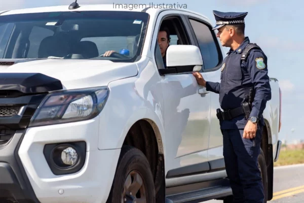 Policial abordando camionete em uma rodovia
